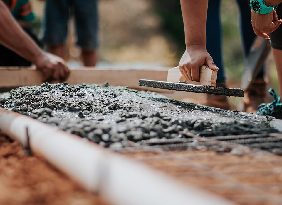 As fases de uma construção precisam ser devidamente planejadas para que nenhuma delas seja o entrave para a finalização do projeto. Afinal, uma depende da outra para sair do papel. Para isso, os especialistas realizam cronograma da obra e elaboram um orçamento completo para garantir a finalização do projeto com muita qualidade e também agilidade. Quais são as fases de uma construção? Toda a obra exige a presença de um especialista, pois a burocracia é bastante exaustiva e nesse processo, exige-se que o projeto seja feito por profissionais conhecedores desse segmento. São muitas as etapas onde o trabalho é bastante intenso e necessário para garantir a segurança da obra. Confira! Documentos A organização da papelada é conhecida como " pré obra" justamente porque é a primeira fase de uma construção e deve ser analisada com bastante cautela, pois é necessário de todas essas etapas, confira: Fazer matrícula do imóvel Solicitar alvará da construção Averiguar atestados da rede elétrica e de água e esgoto Colocar uma placa indicando quem é o responsável pela obra Analisar onde será armazenado os materiais que serão utilizados Contratar os profissionais que irão trabalhar no projeto Decidir onde os resíduos da obra serão descartados Fazer o cronograma da obra para garantir a entrega da obra no prazo estabelecido Preparo do terreno Nessa etapa, é fundamental analisar o terreno onde será realizada a obra, pois em alguns casos é necessário fazer a terraplanagem. Fundação A fundação é uma das fases de uma construção mais importantes, pois é ela que garante a segurança do imóvel. O projeto estrutural da construção é realizado pelo engenheiro e precisa ser seguido com rigorosidade pelo mestre de obra e seus ajudantes. Para esse trabalho são usados materiais como concreto e aço de boa qualidade para não interferir na estrutura do imóvel. Foto para download 2 Erguer as paredes Com a fundação pronta, o imóvel já começa a ganhar suas paredes de alvenaria, neste caso, são necessários tijolos, cimento, areias e outros itens fundamentais. Estrutura Para completar as fases de uma construção onde é determinada a segurança do imóvel chega a parte da colocação de vigas e pilares que darão toda a sustentação necessária. Geralmente são usados concreto armado, porém, outros tipos de materiais têm sido utilizados com sucesso como os tijolos ecológicos, alvenaria estrutural e outros. Elétrica e Hidráulica Sabe-se que a fiação da rede elétrica e hidráulica ficam dentro das paredes, por isso, elas devem ser colocadas nessa fase da construção, ou seja, antes da finalização. Isso quer dizer que essa etapa é bastante trabalhosa, pois entram a colocação do quadro de distribuição de energia, conexões, fios, torneiras, lâmpadas e uma infinidade de cabos e canos. Ademais, se houver sistema de gás e ar condicionado é nesse momento que também devem ser realizadas a estrutura interna. Engenheiros, eletricistas e encanadores devem acompanhar bem esse trabalho. Cobertura É hora de cobrir o imóvel, para isso, é feita uma laje e depois, o telhado é construído. Existem diversas formas de fazer isso, pode ser exposto ou embutido, usar telhas de concreto, cerâmica ou outras. Acabamento Deixar o imóvel mais bonito e bem acabado é uma das fases de uma construção que dão o maior prazer para o responsável da obra, afinal, é a etapa de conclusão. Nessa parte, são colocadas as esquadrias, depois o contrapiso, a colocação dos revestimentos de reboco ou gesso, a instalação dos pisos e das peças sanitárias. Para finalizar, entram a implantação de portas, tomadas, vidros , pintura das paredes, e em alguns casos, a jardinagem e limpeza pós obra. É justamente aqui, nesta fase que pode entrar a execução do piso de concreto estampado. O concreto estampado é indicado para o acabamento de áreas externas, como por exemplo: calçadas, parques, praças, área de lazer, condomínios, ao redores de piscinas, estacionamentos entre outros. De fato, essa é uma das fases de uma construção mais complexas, exige muito conhecimento e principalmente, atenção aos detalhes para deixar o imóvel perfeito. Gostou do conteúdo? Confira também: Por que escolher o concreto estampado?